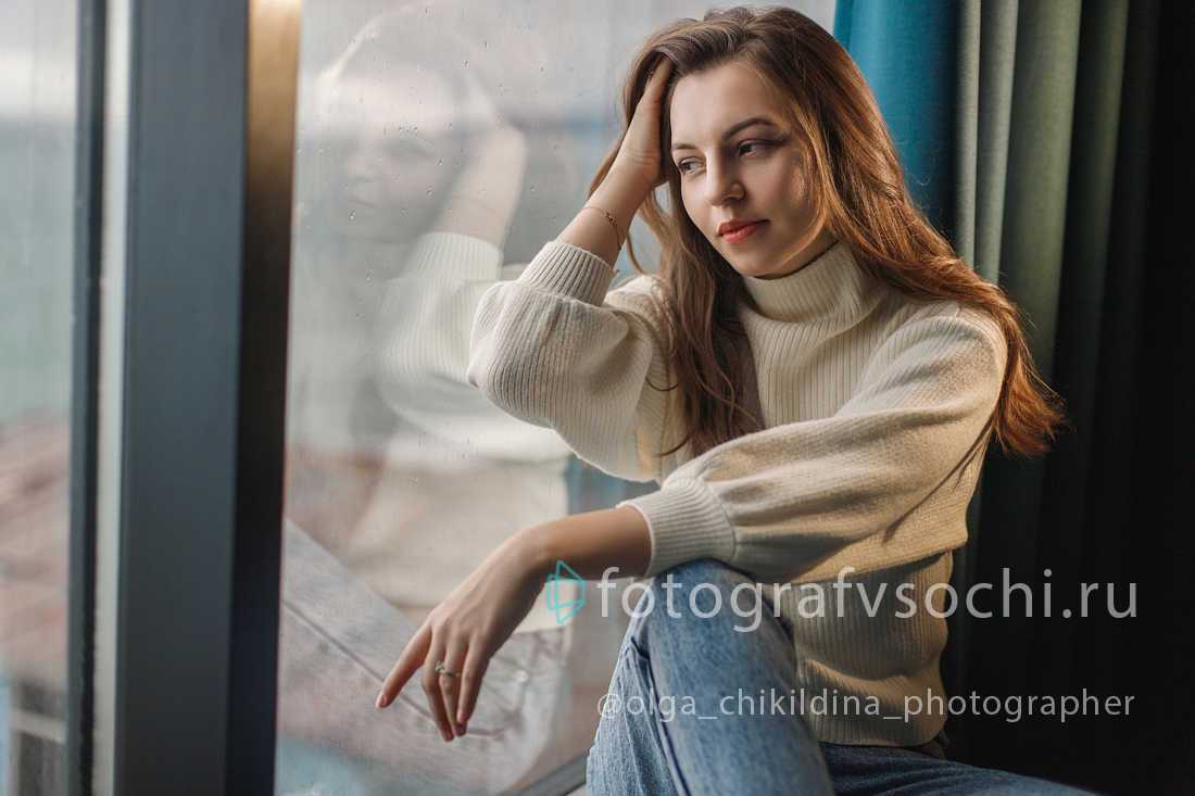 Девушка у окна смотрит на море