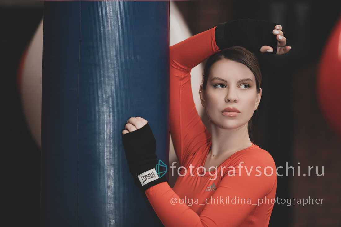 Портрет девушки боксера возле спортивного снаряда (груши)
