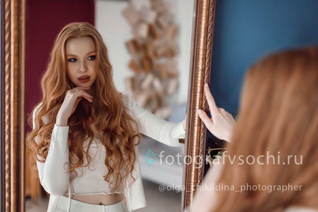 Девушка смотрит в зеркало, отражение в зеркале