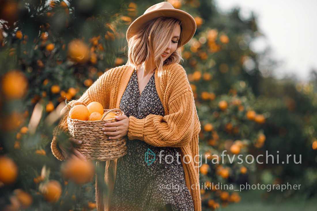 Девушка собирает мандарины