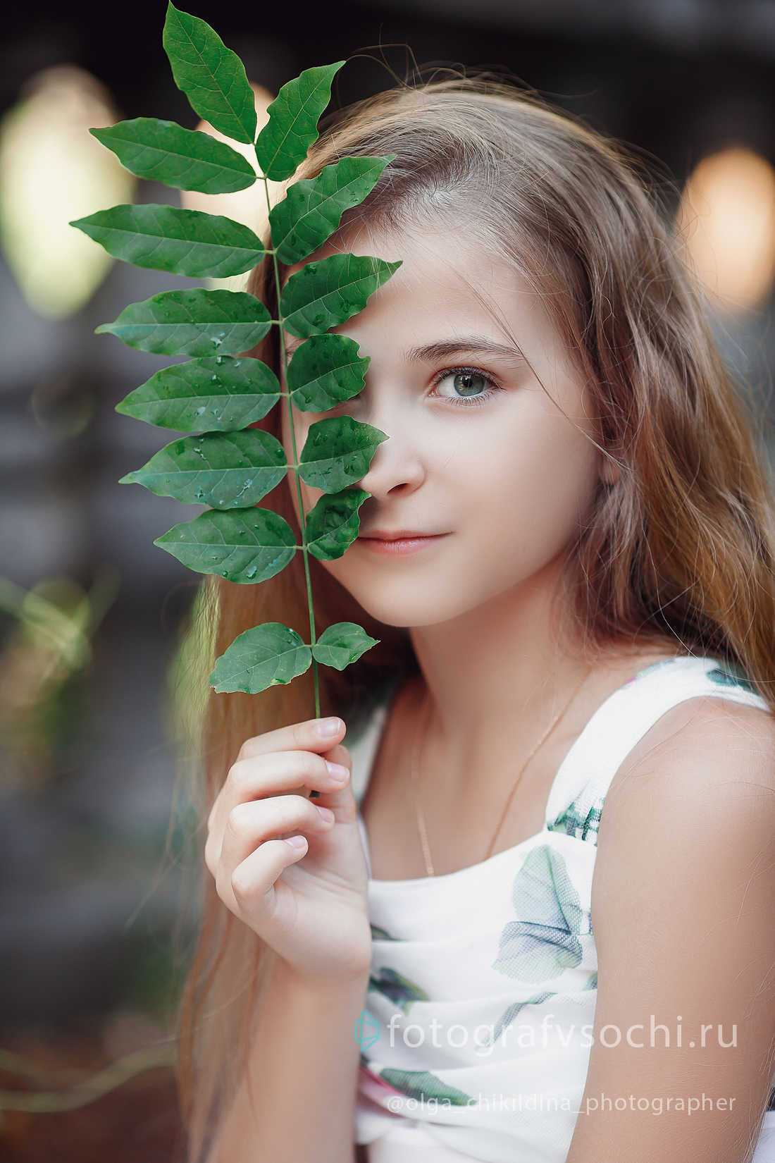 Девочка и веточка с зелеными листьями