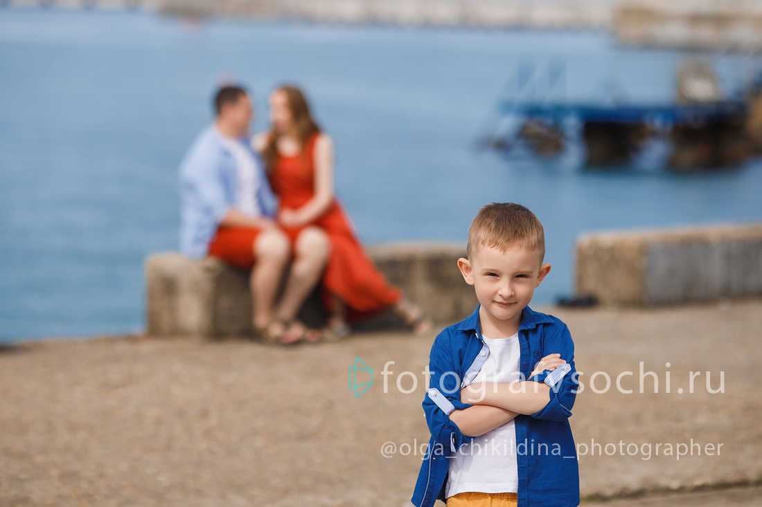 Мальчик на фоне моря у которого сидят родители